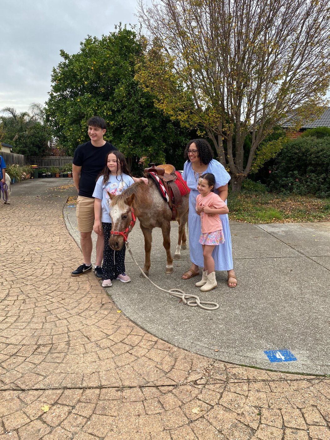 A family posing with a pony during their Little Riders experience