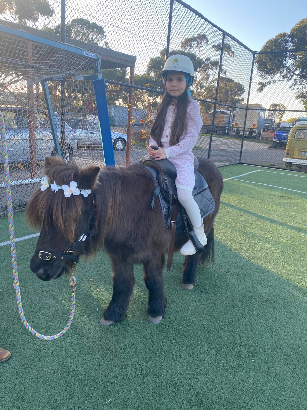 A helmeted child riding a Little Riders miniature pony