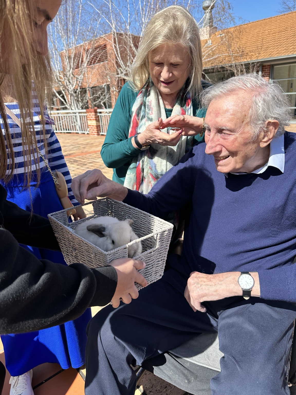A resident gently meeting a rabbit during a small-animal visit